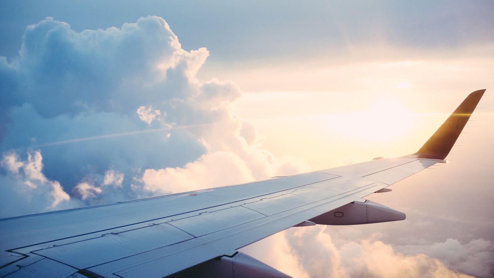Airplane wing above clouds — international travel from Korea